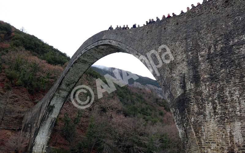 Ο  παπα- Πέτρος, ρίχνει από την κορυφή του μονότοξου ιστορικού γεφυριού της Πλάκας, τον σταυρό στα παγωμένα νερά του ποταμού, στα Τζουμέρκα Ιωαννίνων, τη Δευτέρα 06 Ιανουαρίου 2014. ΑΠΕ-ΜΠΕ/ΑΠΕ-ΜΠΕ/STR