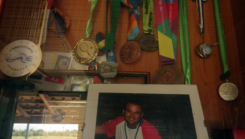 ΕΙΔΙΚΟ ΘΕΜΑ: Τα μετάλλια του Χρήστου Πάκου, ένα «παιδί» με ειδικές ικανότητες που ανέβηκε στο βάθρο των Παγκόσμιων Αγώνων Special Olympics πριν από 2 χρόνια, την Κυριακή 14 Μαΐου 2017. Το ΑΠΕ-ΜΠΕ τους συνάντησε σε μία στροφή του δρόμου, εκεί όπου τελειώνει η συνοικία τα Λευκαδίτικα, στην πόλη της Πρέβεζας, δίπλα σε ένα χωράφι με αγριόχορτα, έξω από ένα σάπιο λυόμενο που είναι το σπίτι τους. Ο πρωταθλητής στη ζωή, με το χάλκινο μετάλλιο στο τένις στους Παγκόσμιους Αγώνες Special Olympics το 2015 στο Λος Άντζελες, ο Χρήστος Πάκος δακρύζει, νιώθει ντροπή και ψελλίζει πως θέλει να ζήσει σε «καλύτερο χώρο», Πέμπτη 18 Μαΐου 2017. ΑΠΕ-ΜΠΕ/ΑΠΕ-ΜΠΕ/ΜΑΙΡΗ ΤΖΩΡΑ
