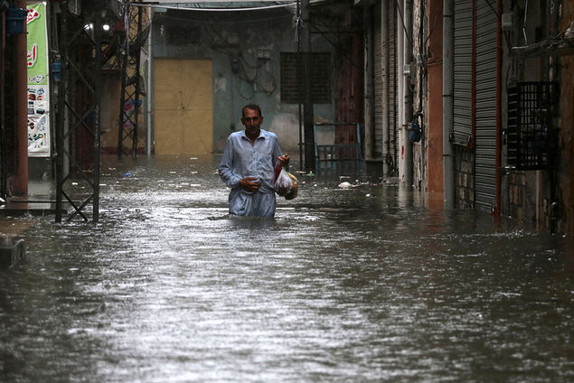 A man wades through a waterlogged street in Rawalpindi, Pakistan EPA/SOHAIL SHAHZAD