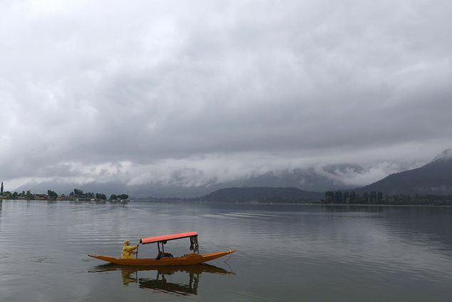 A person rows a boat across the Dal Lake during a rainy day in Srinagar, the summer capital of the Indian-administered Kashmir EPA/FAROOQ KHAN