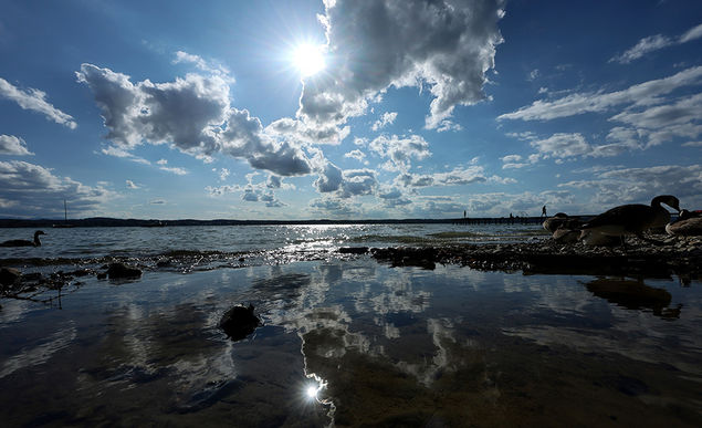  Reflection of clouds on a beach at Lake Starnberg during a sunny day in Seeshaupt, Germany EPA/RONALD WITTEK